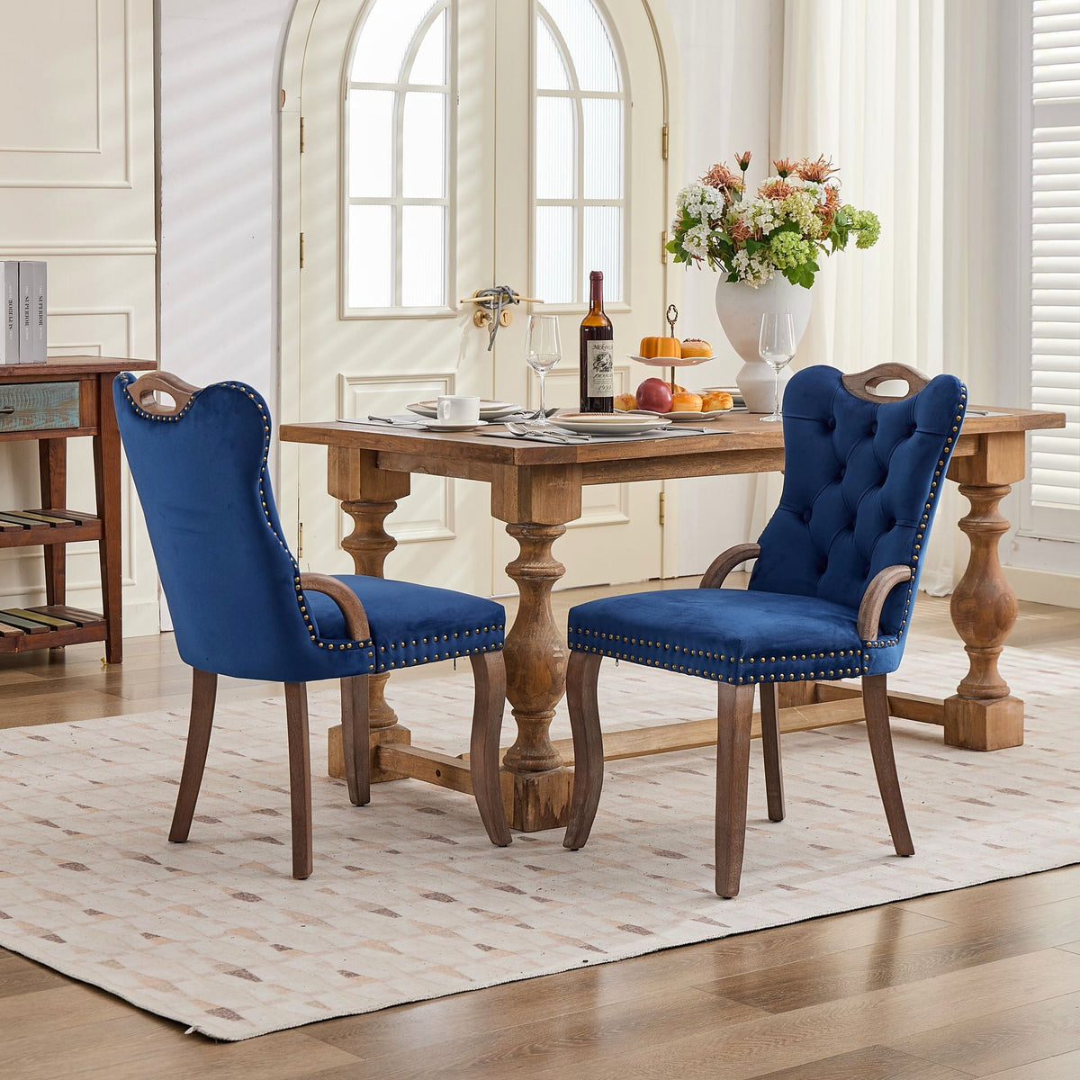Blue velvet dining chair with a tufted back, wood handle, and curved wood legs