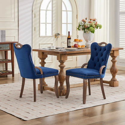 Blue velvet dining chair with a tufted back, wood handle, and curved wood legs