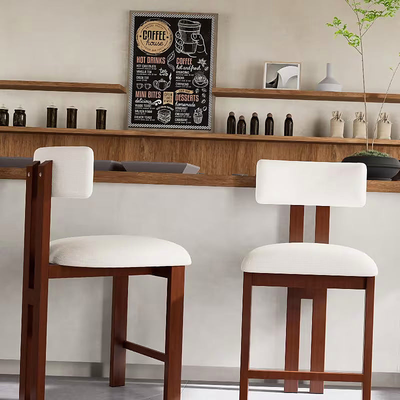 White upholstered counter stool with a brown frame and integrated footrest