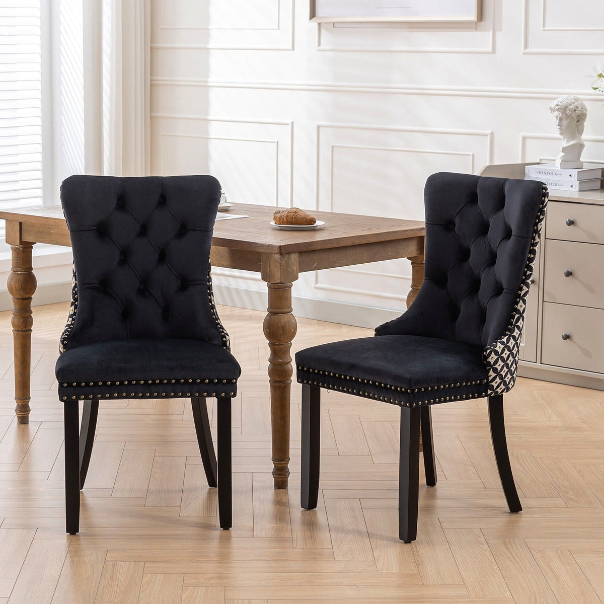 Black velvet dining chair with a patterned back and dark wood legs