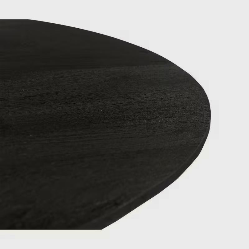 Close-up of the black dining tabletop edge and wood-grain texture