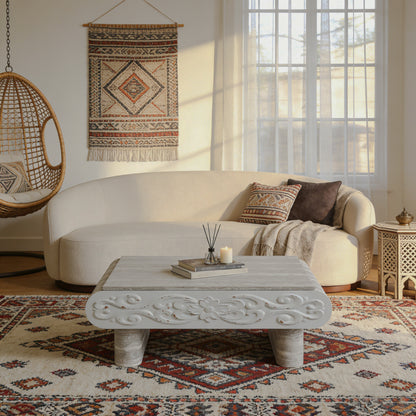 Gray carved lift-top coffee table in front of a curved sofa