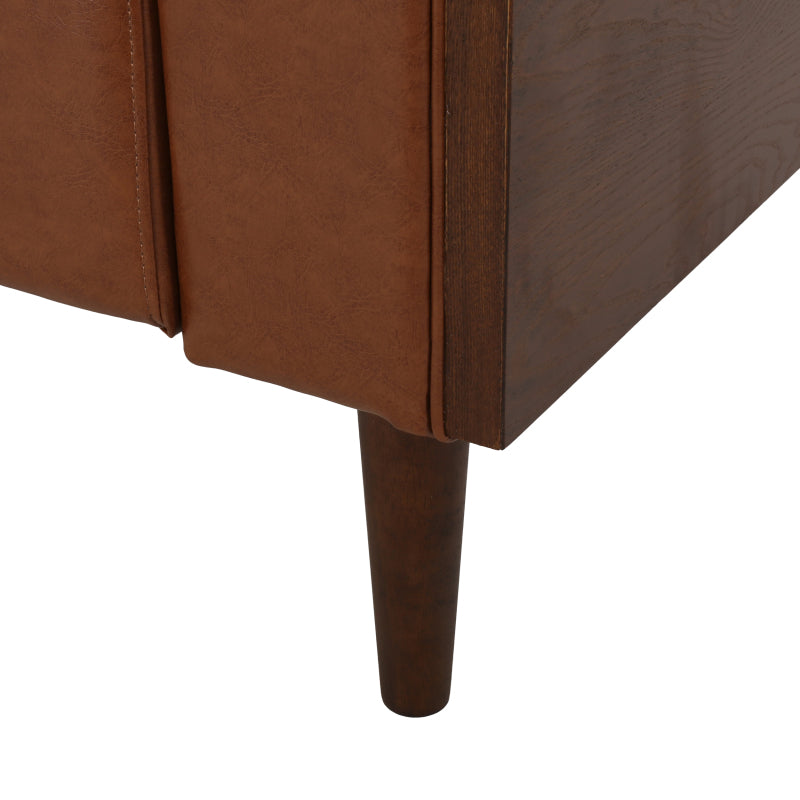 Cognac Button-Tufted Sofa with Bolster Pillows — arm seam and wood leg detail.