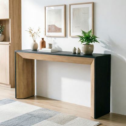 Angled room view of the waterfall console with a vase and potted plant.