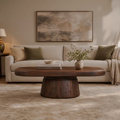 Dark brown pedestal coffee table in front of a beige sofa