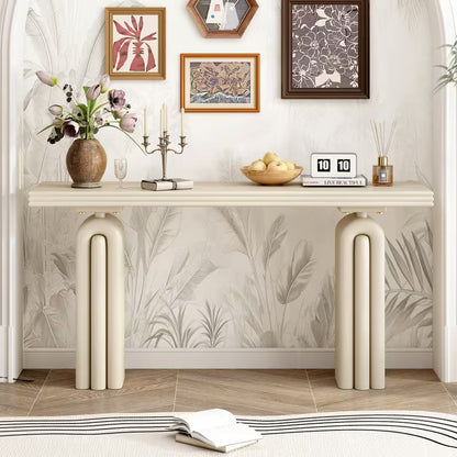 Cream console with layered tabletop and arched pedestal supports in a living room.