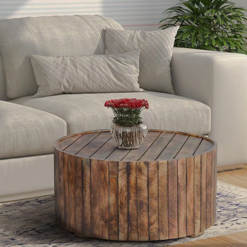 Round brown plank-style coffee table beside a white sofa