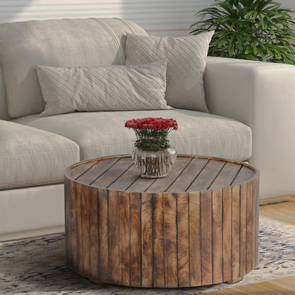 Round brown plank-style coffee table beside a white sofa