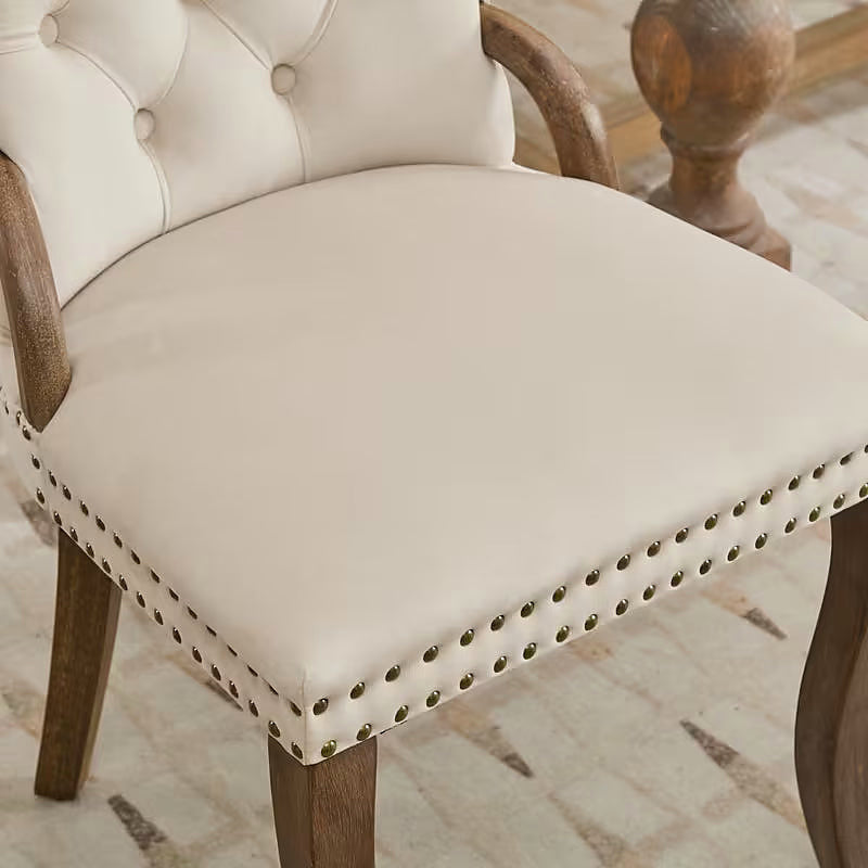 Beige velvet dining chair with a tufted back, wood handle, and curved wood legs