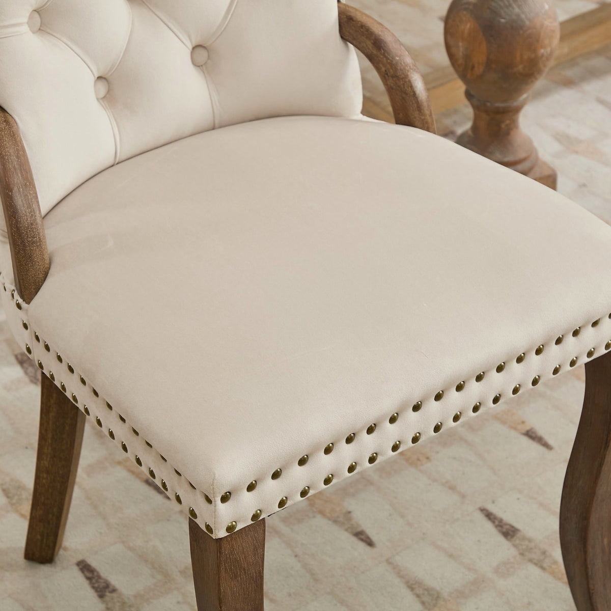 Beige velvet dining chair with a tufted back, wood handle, and curved wood legs