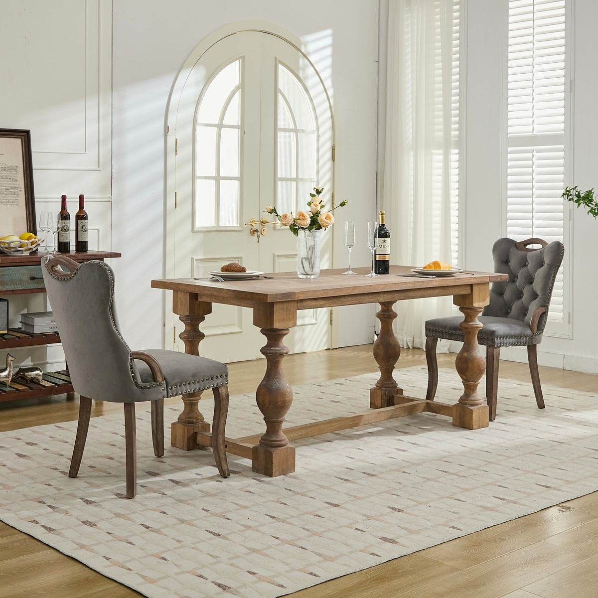 Gray velvet dining chair with a tufted back, wood handle, and curved wood legs