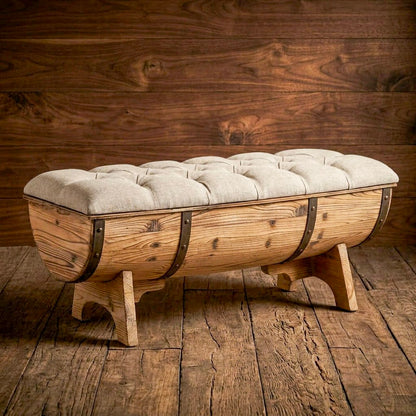 Rustic barrel-style bench with a beige tufted seat and dark bands shown in a wood-paneled room.