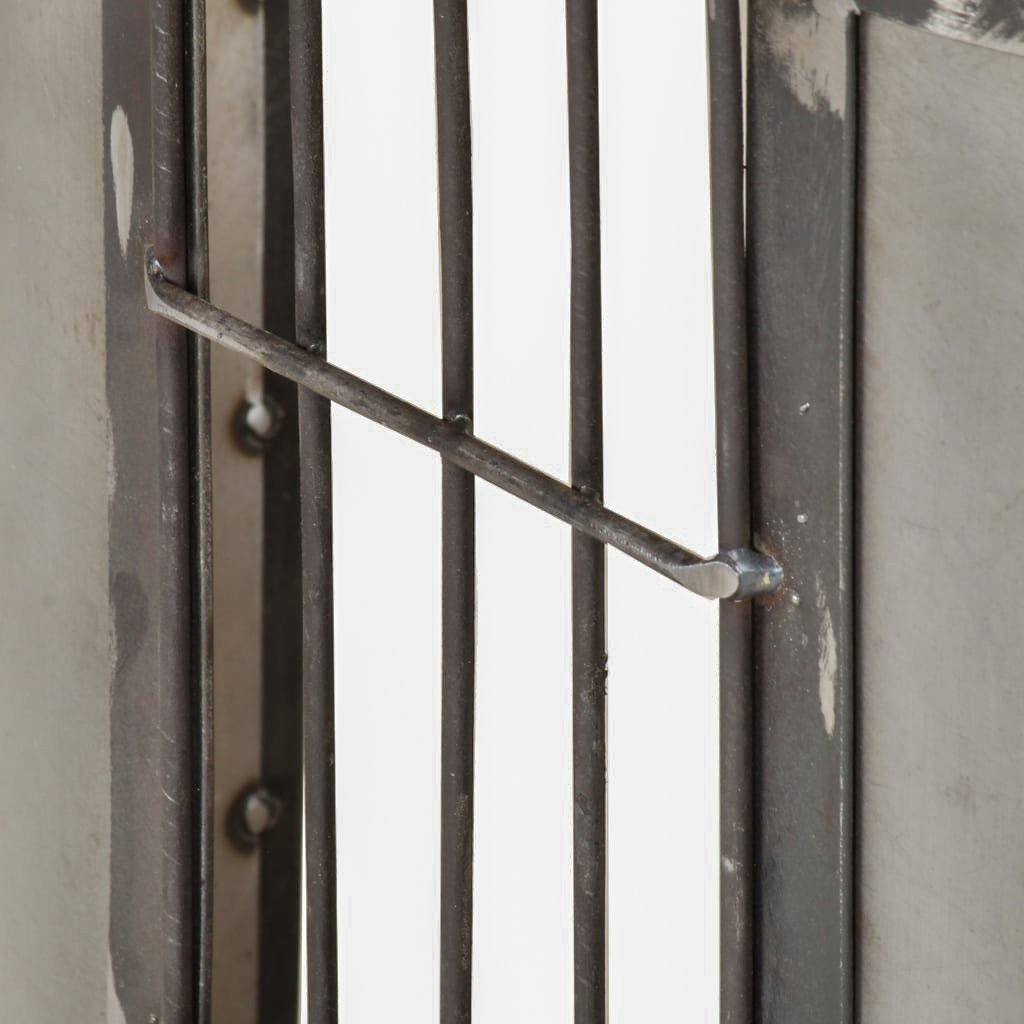 Close-up of the TV stand's gridded metal side detail beside a rounded end panel.