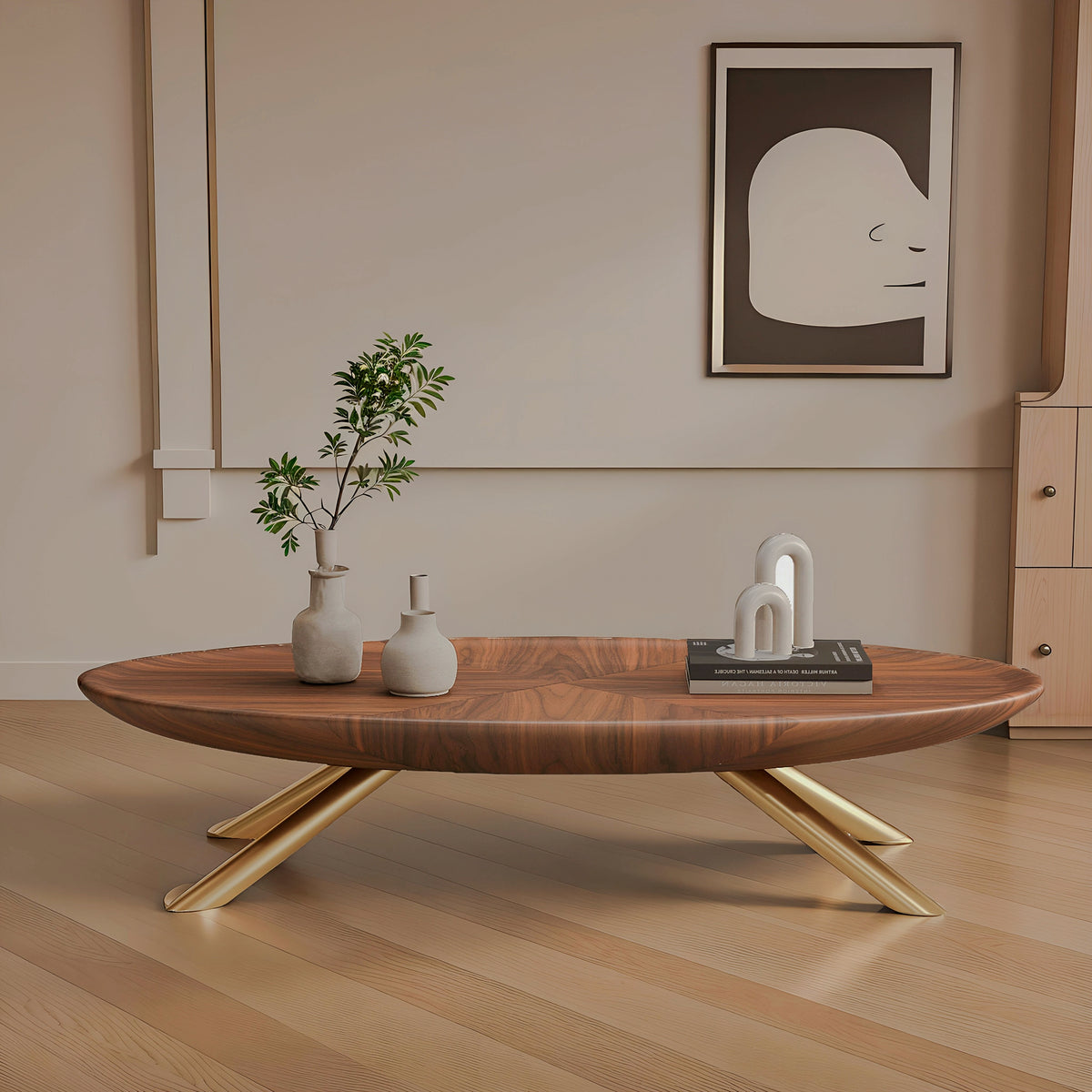 Oval wood-look coffee table with gold-tone crossed legs in a beige living room