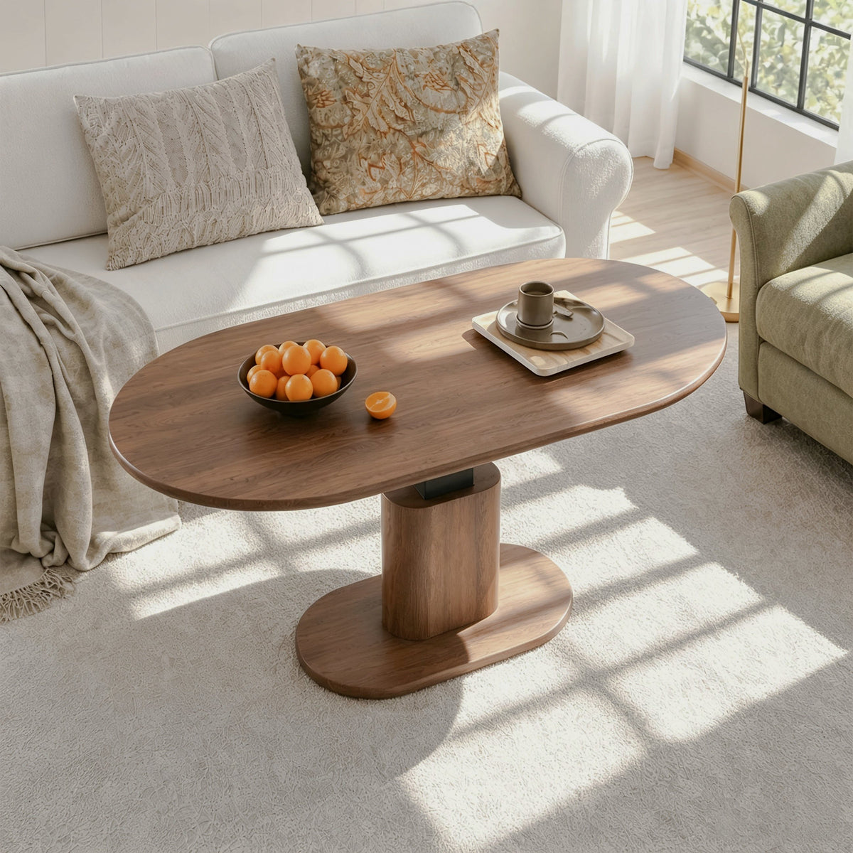 Oval wood-look coffee table on a central pedestal and oval base in a sunlit living room