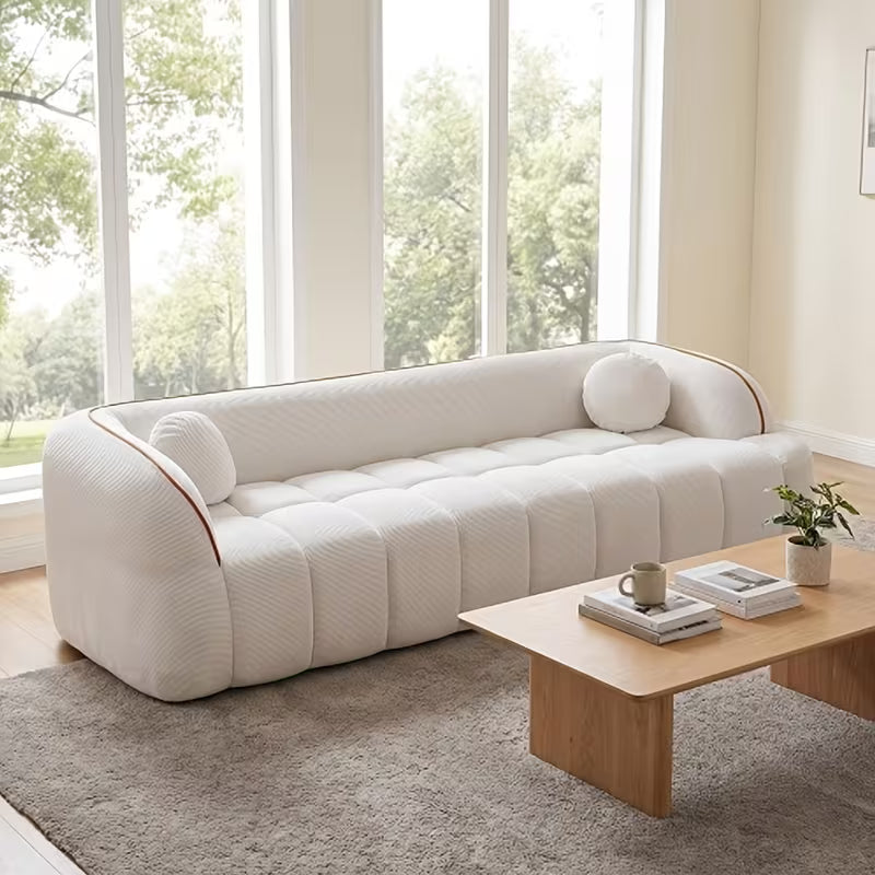 Channel-Tufted Corduroy Lounge Sofa — white sofa beside a window.