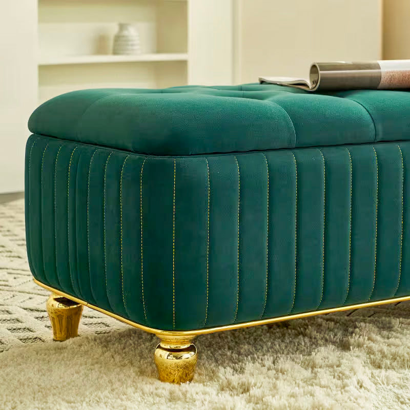 Close view of the green channeled upholstery, gold-tone edging, and turned-style foot