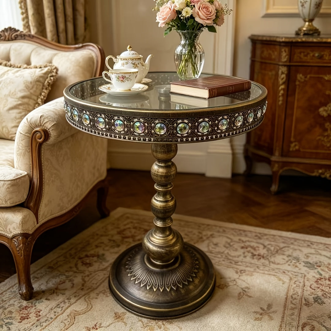 Bronze round side table styled with flowers and a teacup beside a sofa.