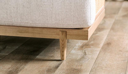 Beige Cane-Side Accent Chair with Bolster Cushions — wood leg and lower frame close-up