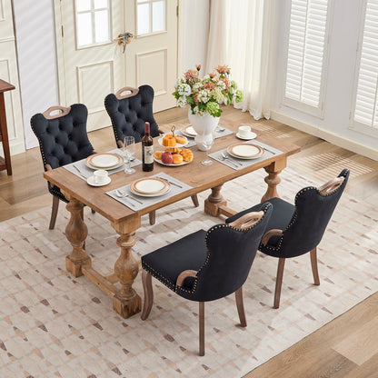 Black velvet dining chair with a tufted back, wood handle, and curved wood legs