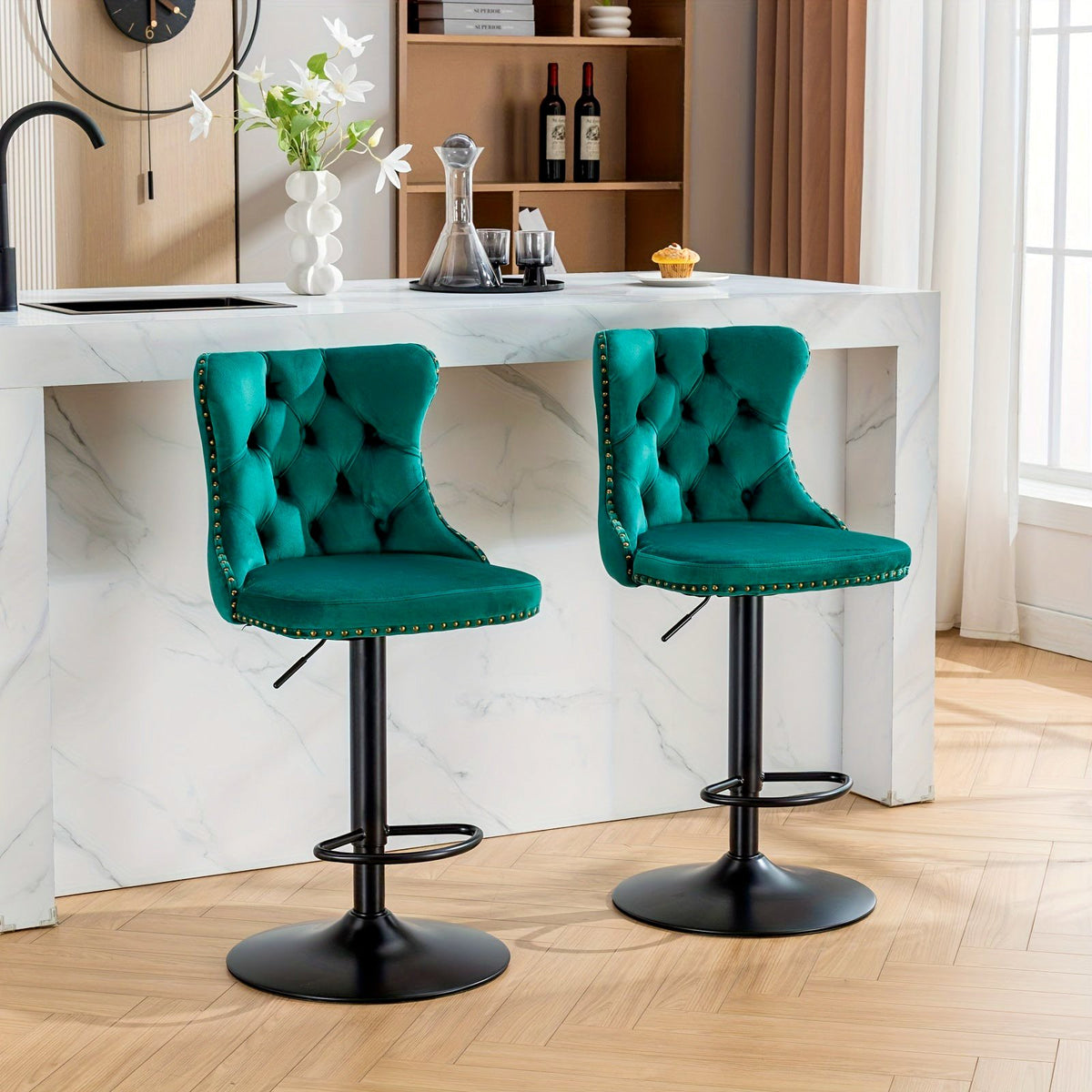 Two teal button-tufted swivel bar stools with black pedestal bases and circular footrests at a kitchen counter