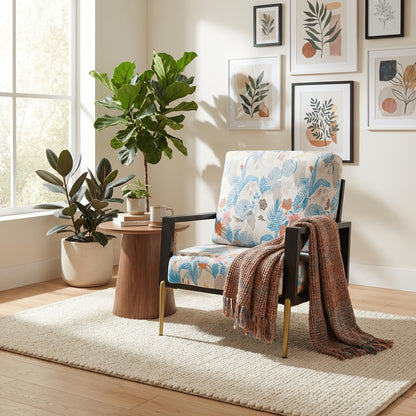Blue and Orange Floral Velvet Accent Chair — floral chair beside a table with a throw on the arm
