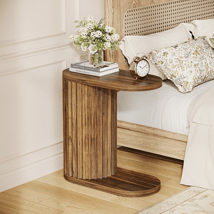Fluted C-shaped table used as a bedside surface.