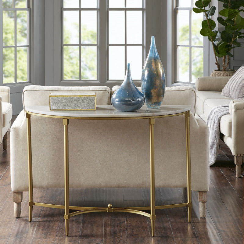 Madison Park Signature Bordeaux console with white half-moon top and gold legs behind a sofa
