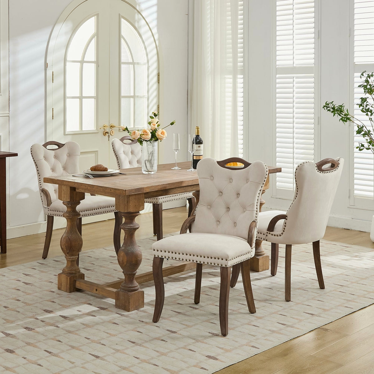 Beige velvet dining chair with a tufted back, wood handle, and curved wood legs