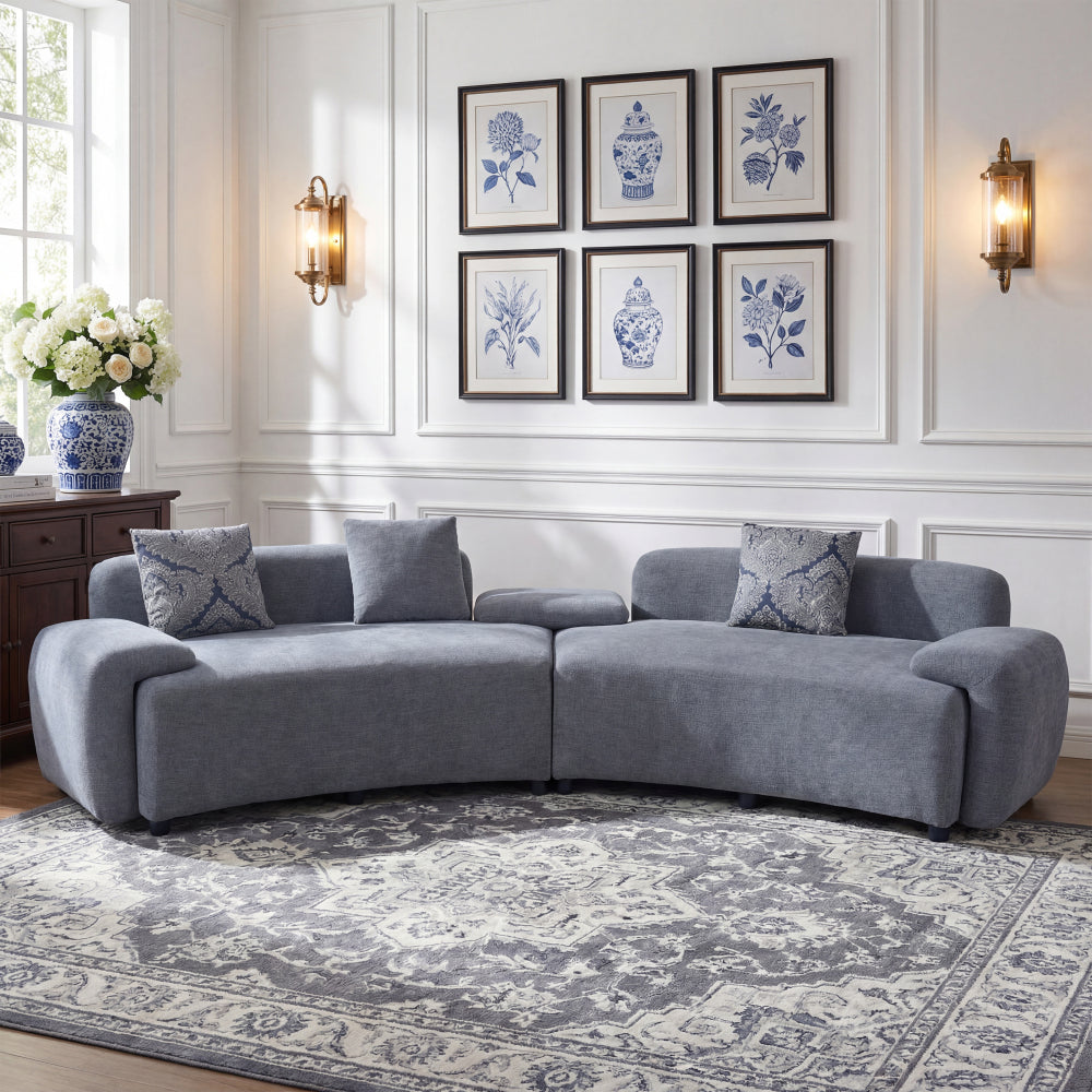 Blue-Grey Curved Sofa with Damask Pillows — front room view with patterned pillows.