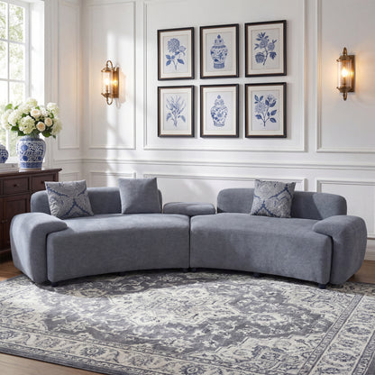 Blue-Grey Curved Sofa with Damask Pillows — front room view with patterned pillows.