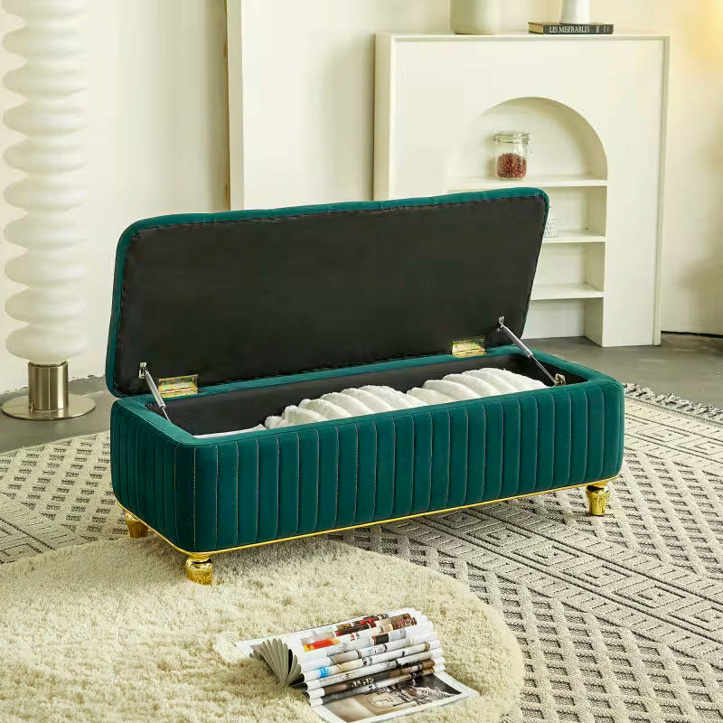 Angled view of the open green storage bench with folded blankets inside