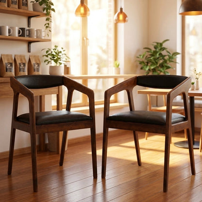 Black faux leather dining armchair with a warm wood frame