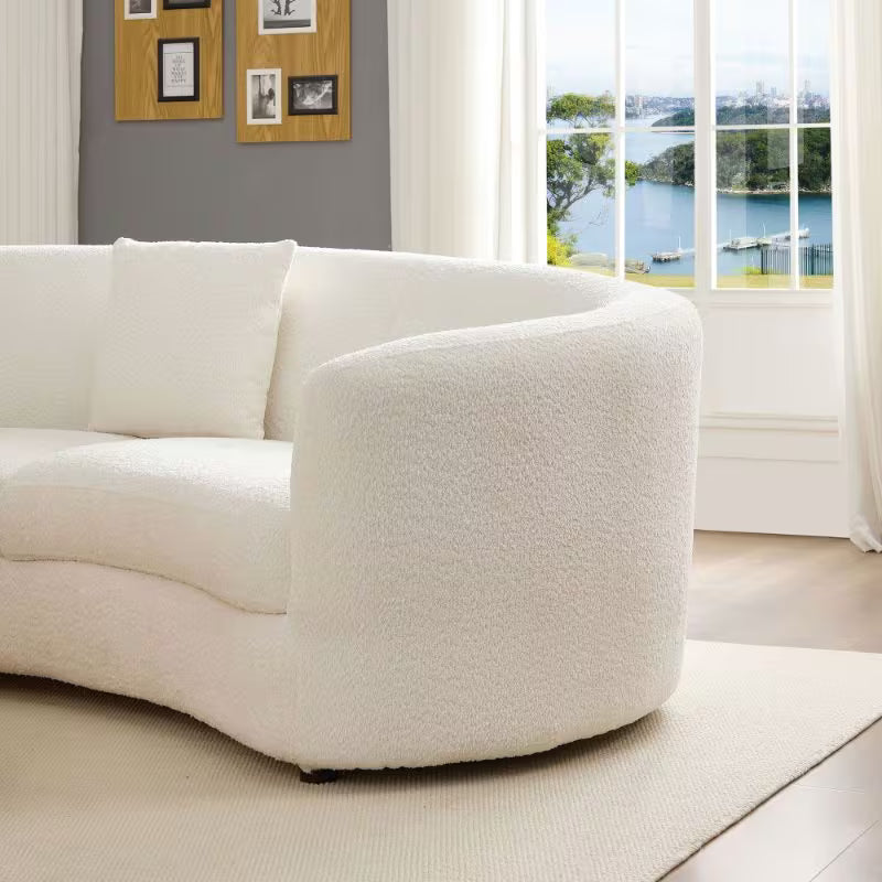 Ivory Curved Sofa with Four Pillows — rounded arm in a living room.