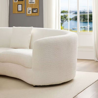 Ivory Curved Sofa with Four Pillows — rounded arm in a living room.