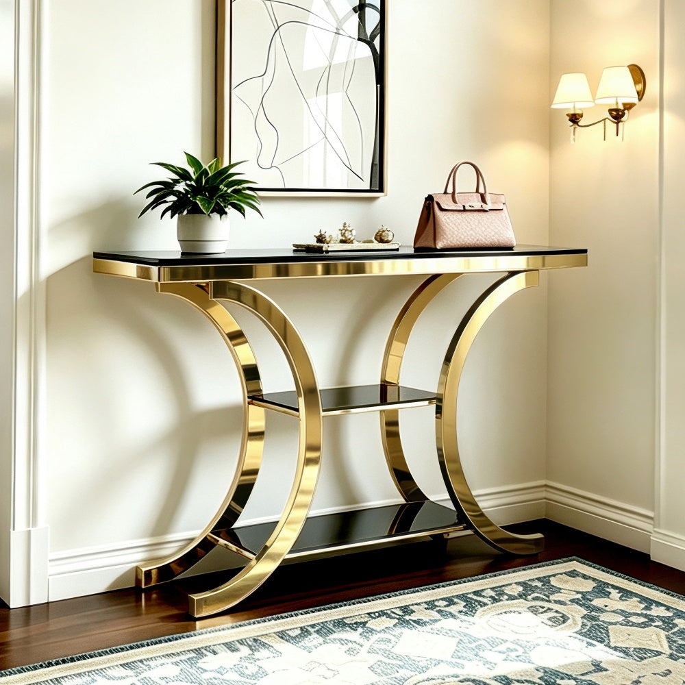 Black and gold crescent-frame console table with a plant and handbag against a paneled wall