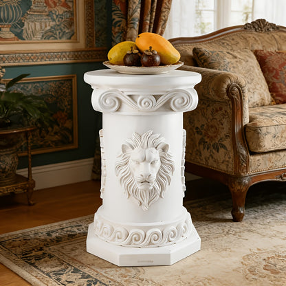 White resin column table styled with fruit near an armchair.