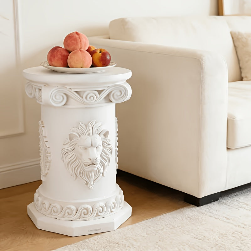 White lion-relief table beside a cream sofa with fruit on its round top.