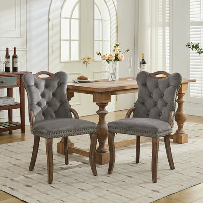 Gray velvet dining chair with a tufted back, wood handle, and curved wood legs