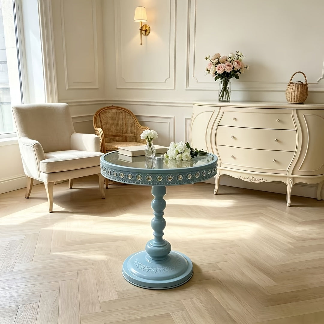 Light blue side table with a rounded pedestal base beside a chair.