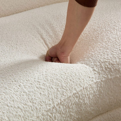 Ivory Curved Sofa with Four Pillows — seat cushion compression demonstration.