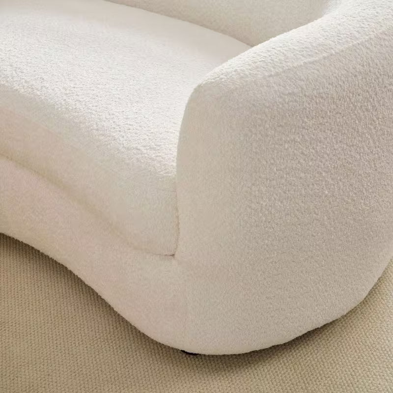 Ivory Curved Sofa with Four Pillows — seat and rounded arm seam detail.