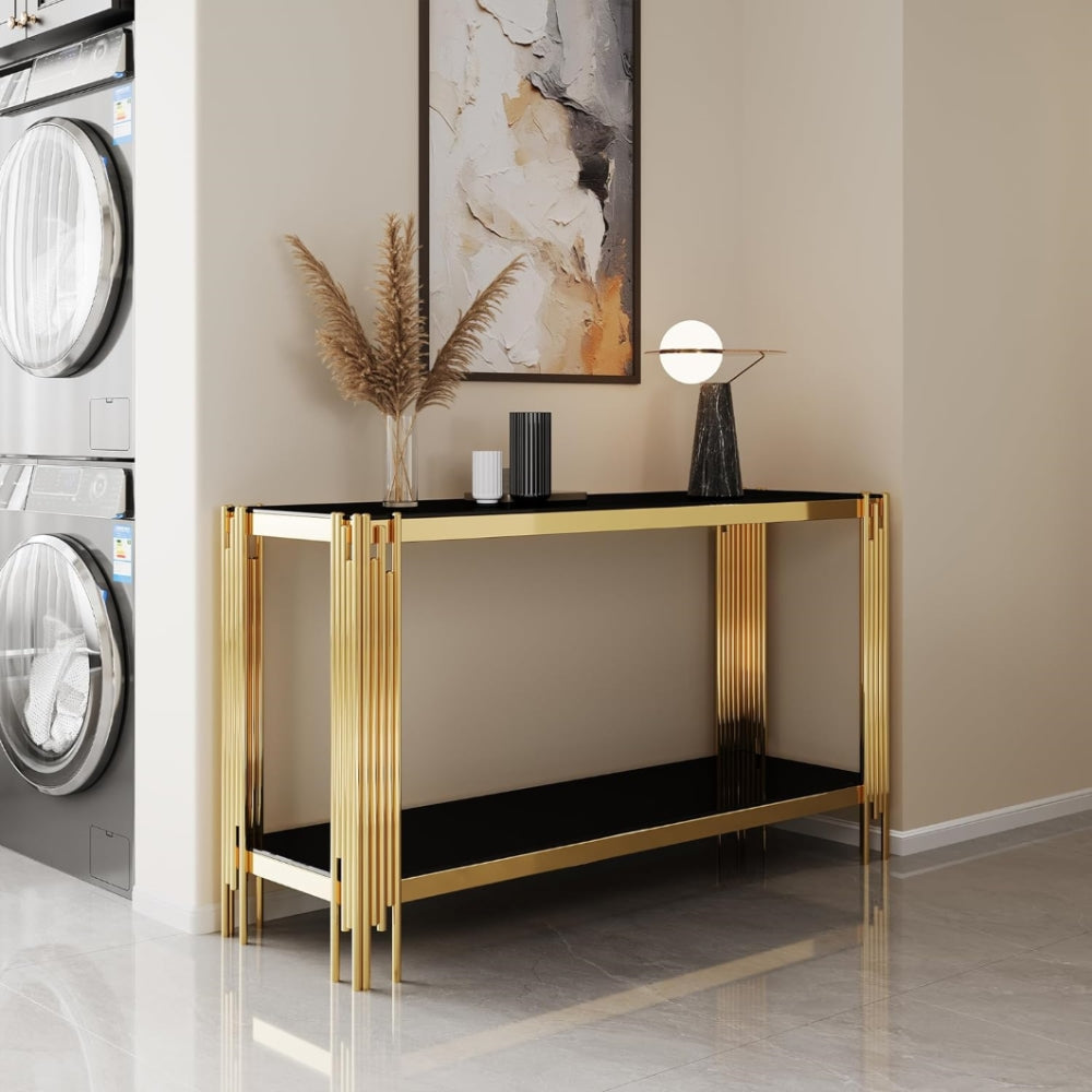 Black glass and gold console styled below wall art.