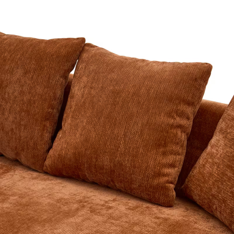 Detail of the orange sofa's loose back cushions