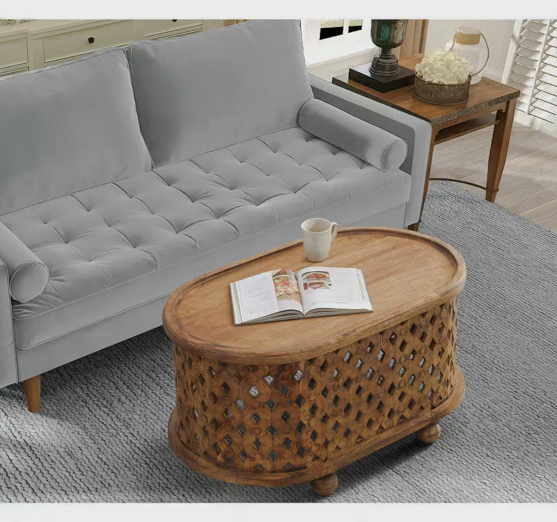 Overhead angled view of an oval brown coffee table beside a gray sofa