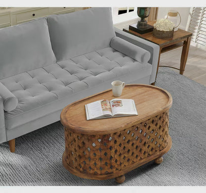 Overhead angled view of an oval brown coffee table beside a gray sofa