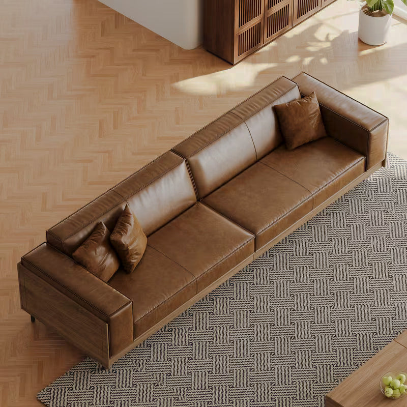 Overhead angled view of the brown sofa's seat cushions and wood frame