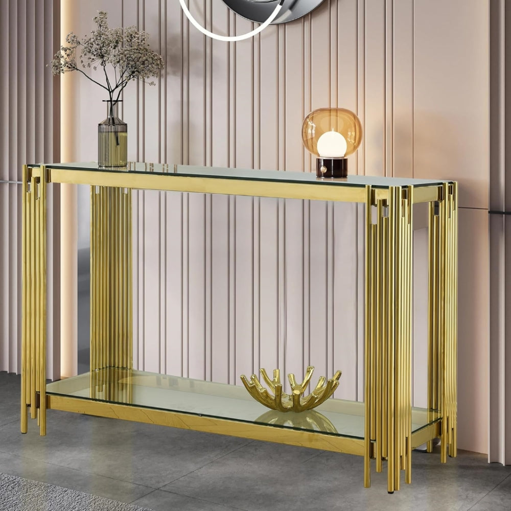 Clear glass and gold frame console styled with a lamp in a modern interior.