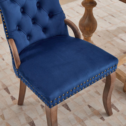 Blue velvet dining chair with a tufted back, wood handle, and curved wood legs