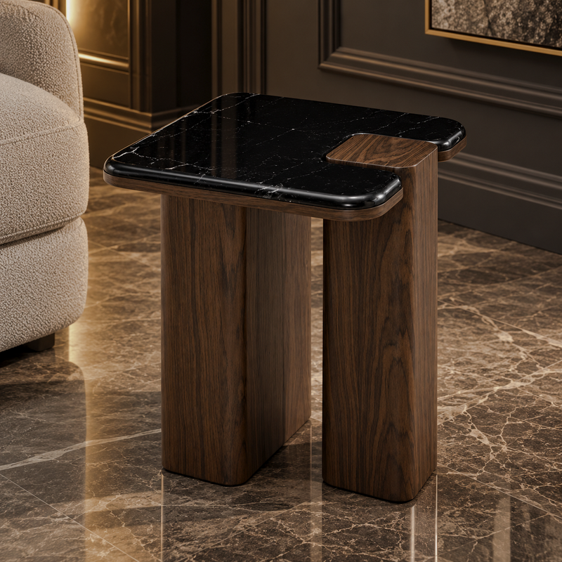 Black marble-look end table with rounded square top and dark brown split-panel supports beside a beige chair